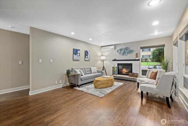 19542 6th Ave NE, Shoreline, WA 98155 - living room featuring a fireplace, recessed lighting, baseboards, a wall unit AC, and dark wood-type flooring