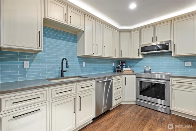 19542 6th Ave NE, Shoreline, WA 98155 - kitchen featuring dark countertops, appliances with stainless steel finishes, a sink, decorative backsplash, and dark wood-style floors