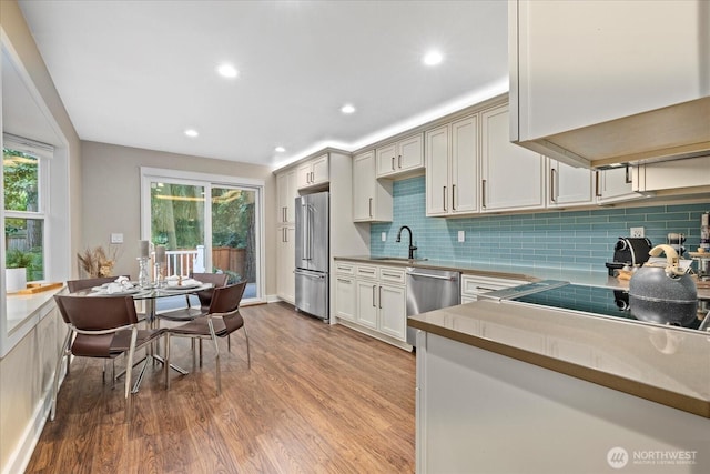 19542 6th Ave NE, Shoreline, WA 98155 - kitchen with light wood-style floors, a sink, backsplash, a wealth of natural light, and stainless steel appliances