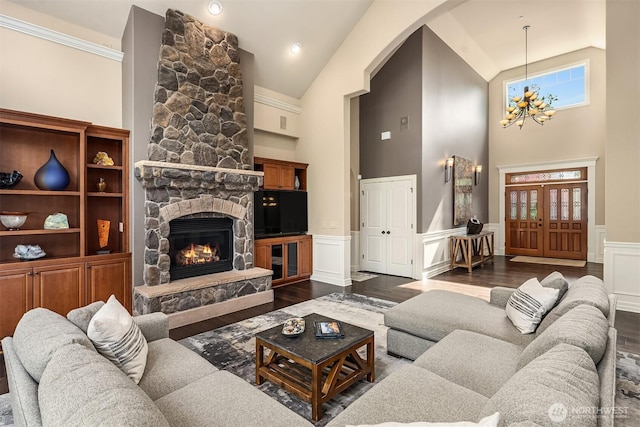 24270 SE 147th Pl, Issaquah, WA 98027 - living room with high vaulted ceiling, a chandelier, dark wood-style flooring, a stone fireplace, and wainscoting