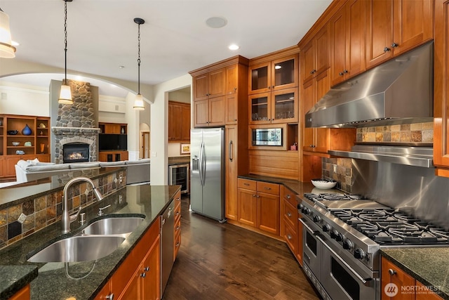 24270 SE 147th Pl, Issaquah, WA 98027 - kitchen with under cabinet range hood, stainless steel appliances, a sink, brown cabinetry, and wine cooler