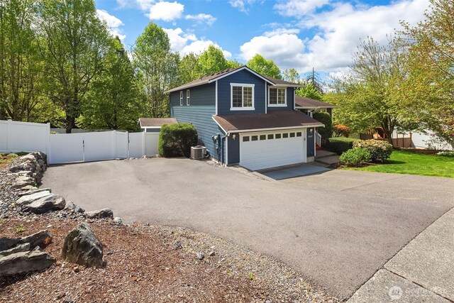 27627 NE 140th Pl, Duvall, WA 98019 - view of side of property featuring fence, a shingled roof, aphalt driveway, a garage, and central air condition unit