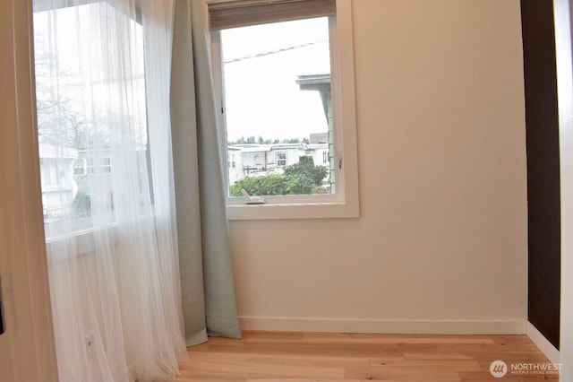 empty room with baseboards and light wood-style floors