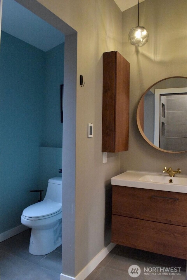 bathroom featuring baseboards, tile patterned floors, vanity, and toilet