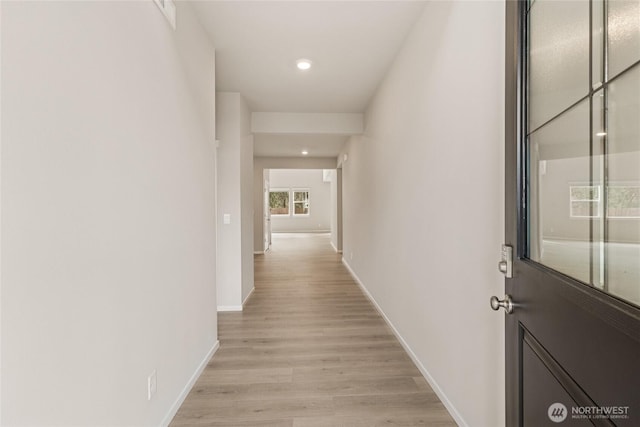 hall with baseboards, recessed lighting, and light wood-style floors