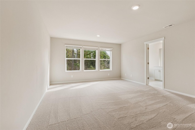 unfurnished room featuring baseboards, light colored carpet, recessed lighting, and visible vents