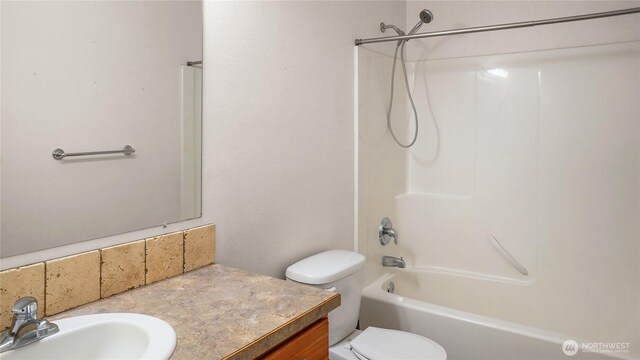 bathroom featuring toilet, bathing tub / shower combination, and vanity