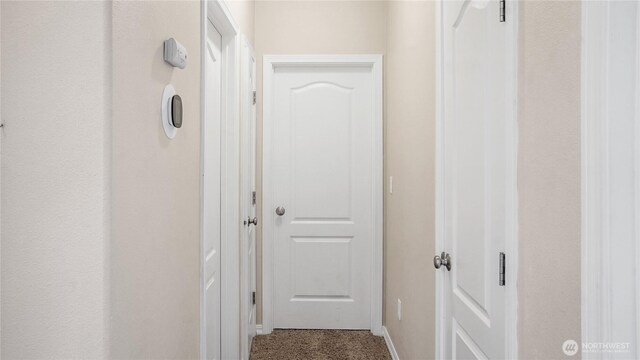 hall with carpet floors and baseboards