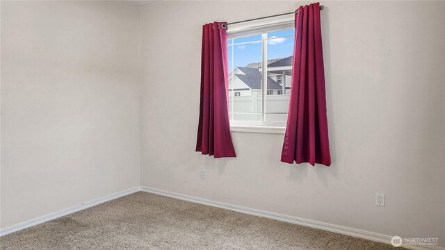 carpeted spare room with baseboards