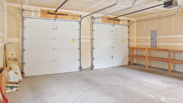 garage with a garage door opener and electric panel