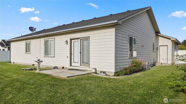 rear view of property featuring a lawn and a patio area