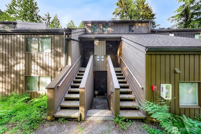 view of exterior entry with a shingled roof