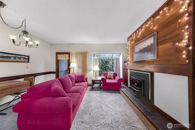 living area with carpet floors, a textured ceiling, an inviting chandelier, and a wood stove