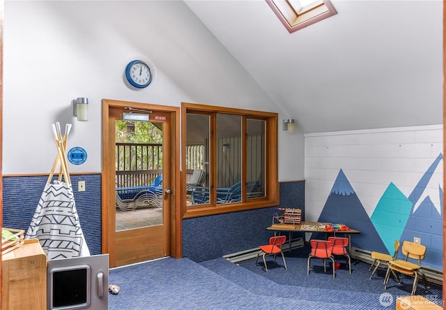 recreation room with carpet floors and vaulted ceiling with skylight