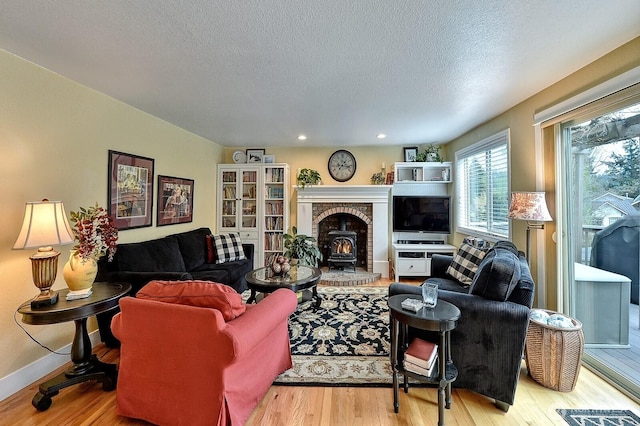 3506 S Grace Ln, Bellingham, WA 98226 - living room with a wood stove, wood finished floors, baseboards, recessed lighting, and a textured ceiling
