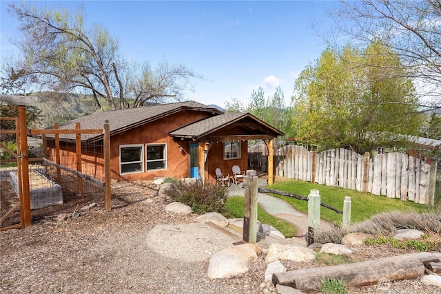 811 Filer Ave, Winthrop, WA 98862 - exterior space featuring a patio, a shingled roof, a fenced backyard, and stucco siding