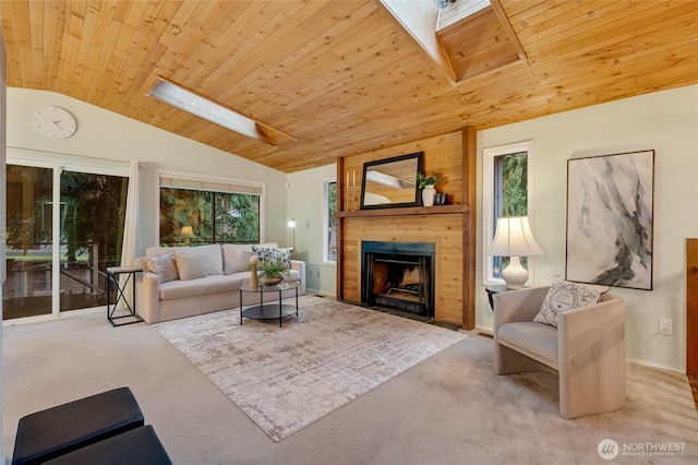 living area with carpet floors, baseboards, lofted ceiling with skylight, wood ceiling, and a fireplace with flush hearth