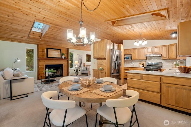 dining space with an inviting chandelier, vaulted ceiling with skylight, wooden ceiling, and a wealth of natural light