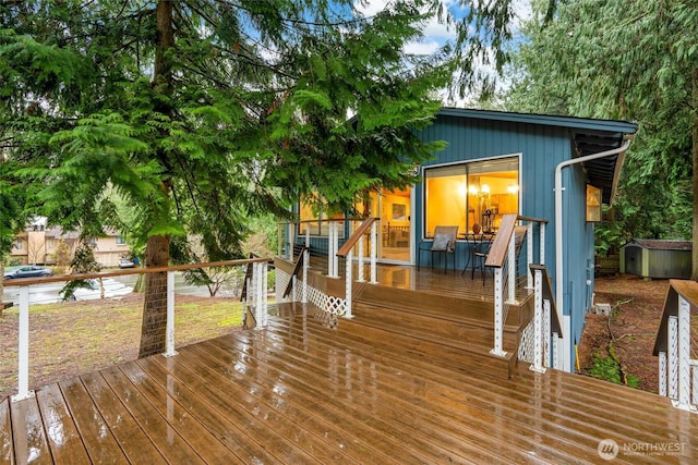 wooden terrace with a storage unit and an outdoor structure