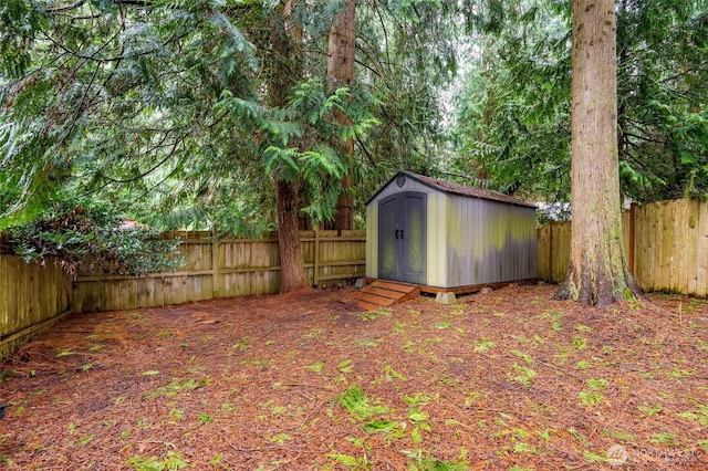 view of yard with an outdoor structure, a fenced backyard, and a shed