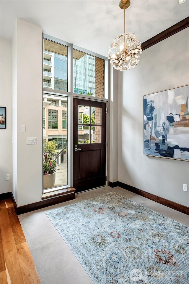 entryway with baseboards and an inviting chandelier