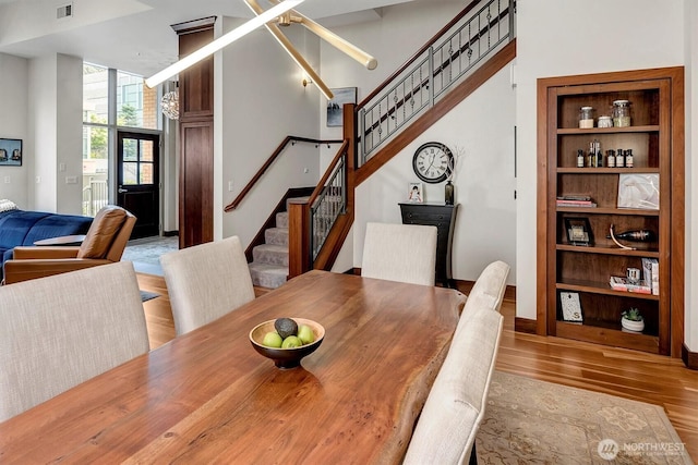 dining area with stairway, wood finished floors, and visible vents