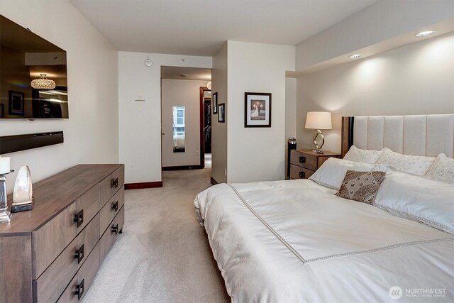 bedroom with baseboards and light colored carpet