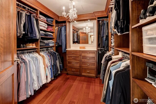 spacious closet featuring a notable chandelier and dark wood-style floors