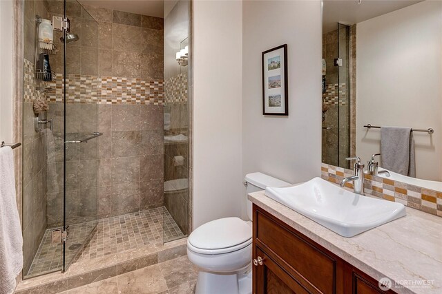 bathroom featuring vanity, toilet, and a shower stall