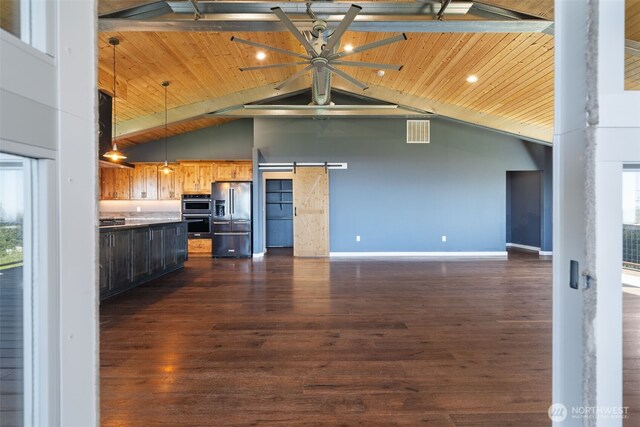 unfurnished living room with a barn door, high vaulted ceiling, beamed ceiling, dark wood-style floors, and wood ceiling