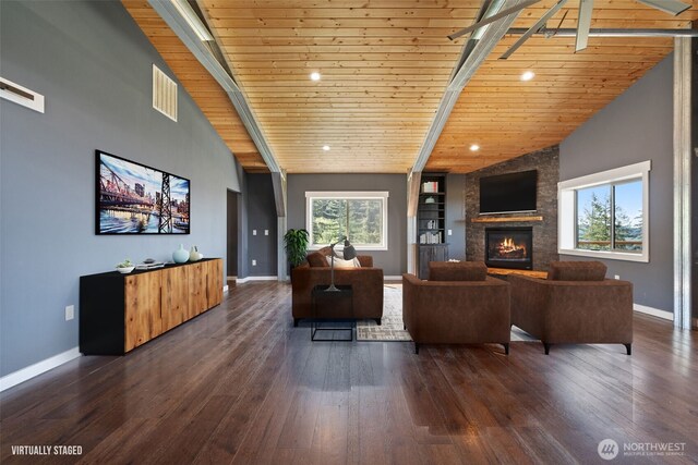 living area with wooden ceiling, baseboards, a stone fireplace, dark wood-type flooring, and beamed ceiling