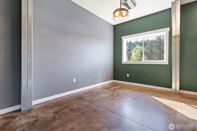 unfurnished room featuring finished concrete flooring and baseboards