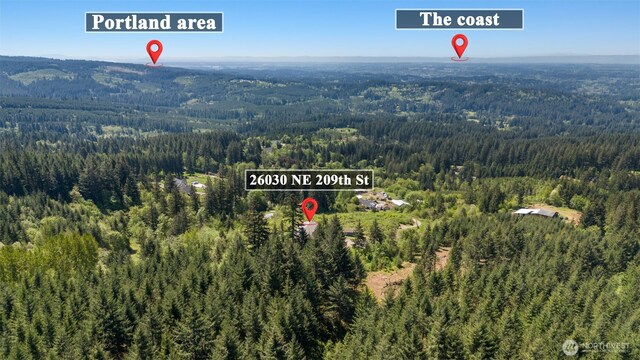aerial view of property and surrounding area with a heavily wooded area