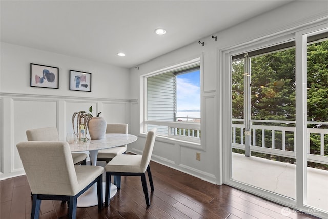 dining room featuring recessed lighting, a decorative wall, dark wood-style floors, and a wainscoted wall