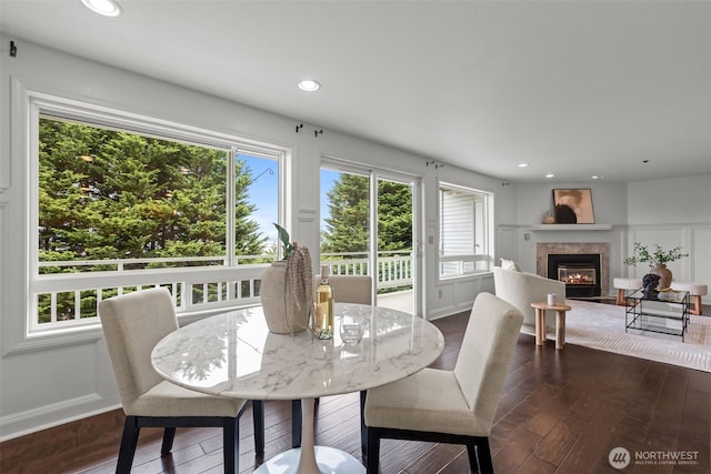 dining room featuring recessed lighting, a fireplace with flush hearth, dark wood finished floors, and baseboards