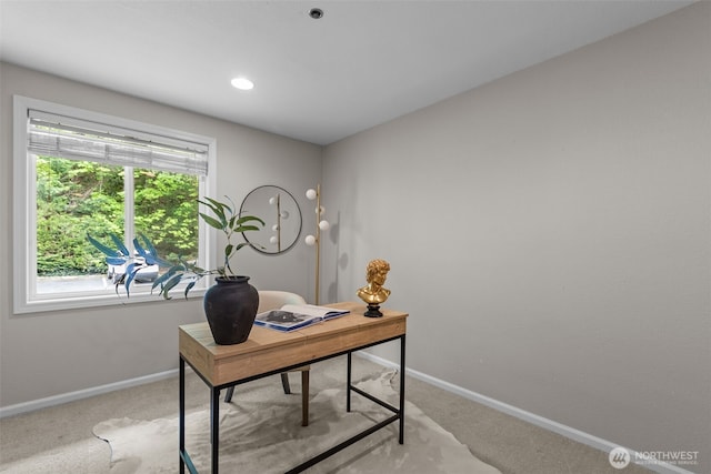 office space with baseboards and light colored carpet
