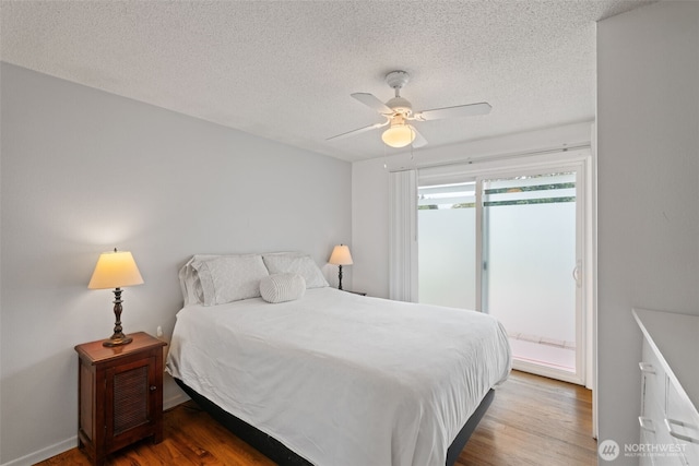 bedroom with a textured ceiling, wood finished floors, access to exterior, and ceiling fan