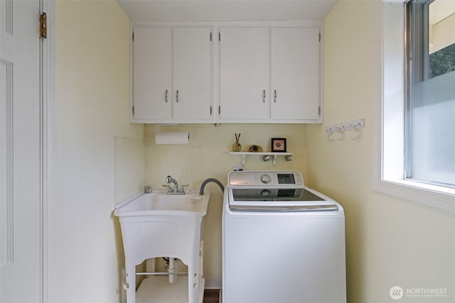 laundry area with washer / dryer, a sink, and cabinet space