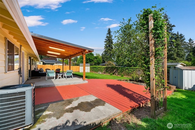 exterior space featuring a storage unit, central air condition unit, an outdoor structure, a fenced backyard, and a patio area