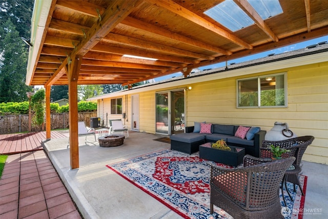 view of patio / terrace with an outdoor living space with a fire pit, fence, and a wooden deck