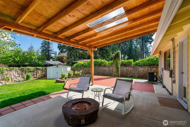 view of patio with cooling unit, a fenced backyard, a fire pit, and a storage unit
