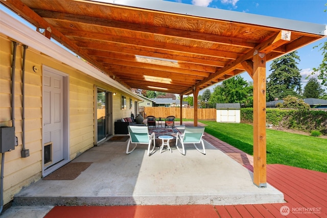 view of patio featuring an outdoor structure, fence, and a storage unit