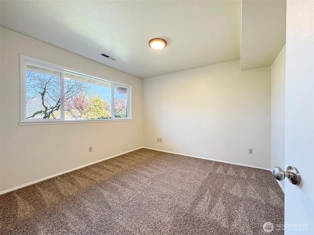 carpeted empty room with baseboards, a textured ceiling, and visible vents