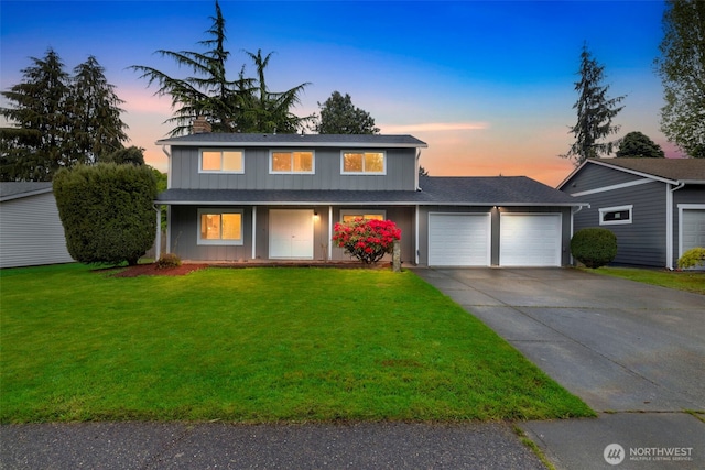 traditional home with a garage, covered porch, driveway, roof with shingles, and a yard