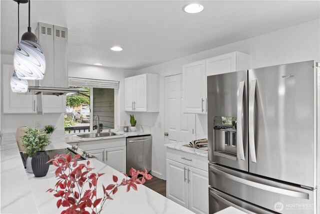 kitchen featuring appliances with stainless steel finishes, a sink, light countertops, white cabinetry, and recessed lighting
