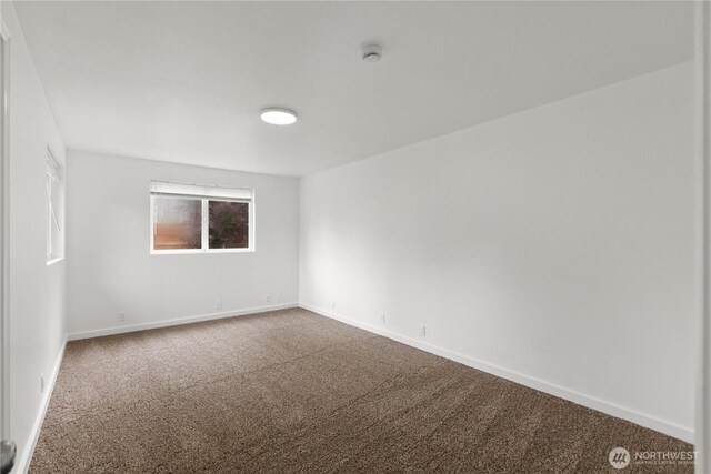 spare room featuring carpet, a smoke detector, and baseboards