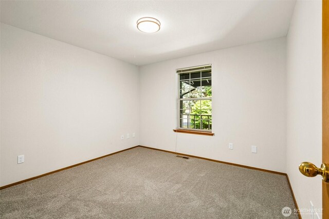 carpeted empty room with visible vents and baseboards