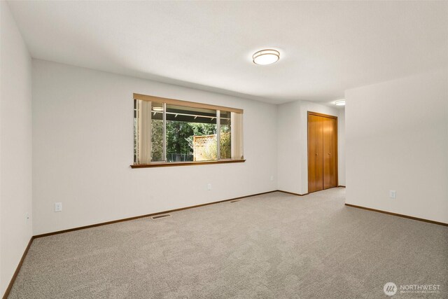 carpeted empty room with baseboards and visible vents