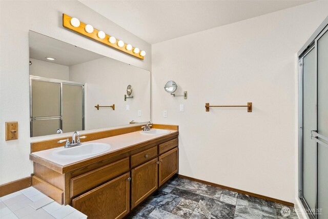 full bath featuring baseboards, a sink, and a stall shower