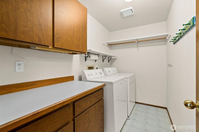 laundry area featuring visible vents, washing machine and clothes dryer, cabinet space, baseboards, and light floors